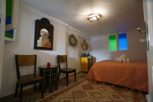 a bedroom with a bed and two chairs and a mirror at DAR AMR in Tangier