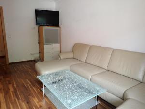 a living room with a white couch and a glass coffee table at Ferienwohnungen Lend 3 in Lend