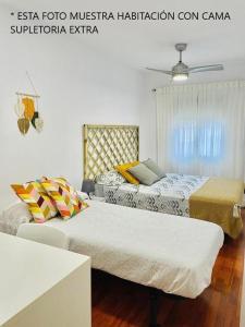- une chambre avec deux lits et un canapé dans l'établissement Apartamento ABRIL en el Centro de Getafe, à Getafe