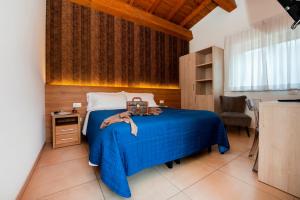 ein Schlafzimmer mit einem blauen Bett und einer blauen Decke in der Unterkunft Gu Hotel in Guidonia