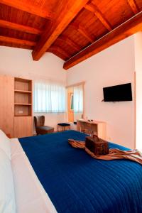 sypialnia z dużym niebieskim łóżkiem i telewizorem z płaskim ekranem w obiekcie Gu Hotel w mieście Guidonia Montecelio