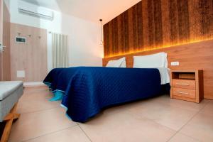 ein Schlafzimmer mit einem Bett mit einer blauen Decke darauf in der Unterkunft Gu Hotel in Guidonia