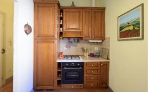 a kitchen with wooden cabinets and a stove top oven at Appartamento di Lusso in Borgo Storico Toscano in Bibbiena +13 photos