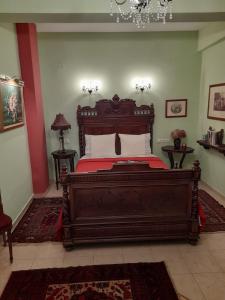 Un dormitorio con una gran cama de madera con sábanas rojas. en Ktima Samanli en Kissós