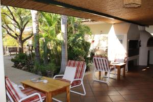 a patio with two chairs and a table and a table at Blommenberg Guest House in Clanwilliam