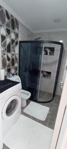 uma casa de banho com uma máquina de lavar roupa e um WC em Sabinanın sıcak evi em Didim