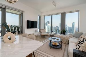 a living room with a couch and a table at Prestige Living 2BR with Full Burj Khalifa and Fountain View by Auberge in Dubai