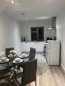 a living room with a table and chairs and a refrigerator at Newly built one bedroom flat in Kidlington, Oxfordshire in Kidlington