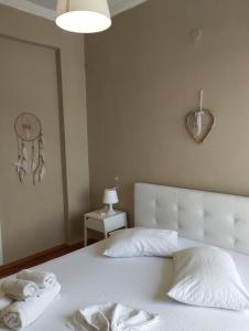 een slaapkamer met een groot wit bed en handdoeken bij Ionias Penthouse in Korinthos