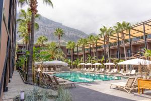 a hotel with a swimming pool with chairs and umbrellas at Golden Sun Hotel Adult Only in Beldibi