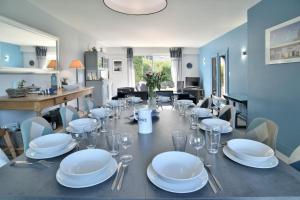 ein Esszimmer mit einem Tisch mit Tellern und Weingläsern in der Unterkunft Villa des Daules in Cancale