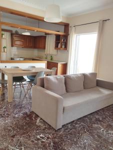 een woonkamer met een bank en een tafel bij Ionias Penthouse in Korinthos