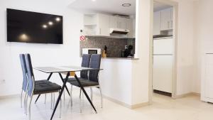 a dining room with a table and chairs and a kitchen at Royal II in Salou