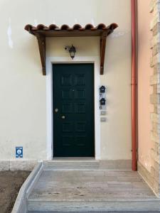 una puerta verde al lado de un edificio en PICCOLO BORGO MOLISANO, en Indiprete