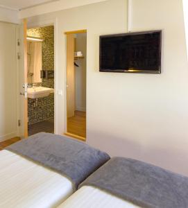 1 dormitorio con 1 cama y TV en la pared en Good Morning Lund, en Lund