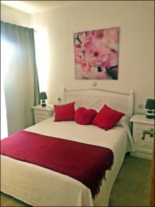 ベナルマデナにあるBenalbeach Apartment With Water Parkのベッドルーム1室(大型ベッド1台、赤い枕付)