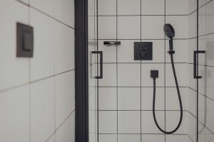 a shower with a shower head in a bathroom at Les 3 Cabanes Urbaines - centre historique in Namur