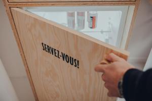 a person holding a piece of wood with the words service yourself at Les 3 Cabanes Urbaines - centre historique in Namur