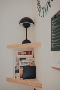 a black lamp sitting on top of a shelf with books at Les 3 Cabanes Urbaines - centre historique in Namur