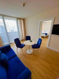 un soggiorno con divano, tavolo e sedie di Orbi City Apartment Sea View a Batumi