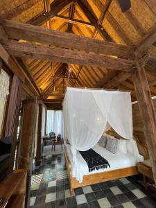 Ce lit se trouve dans un dortoir doté d'un plafond en bois. dans l'établissement Umakayu Joglo Villa Canggu - Boutique Hotel, à Canggu