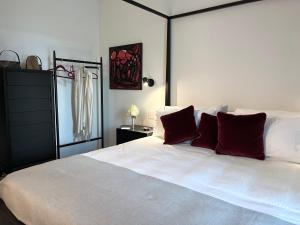 a bedroom with a large white bed with red pillows at The Iconic Lodge in Bellagio