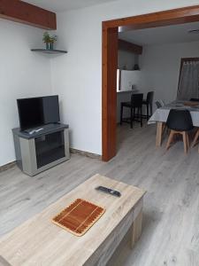 un soggiorno con tavolo e TV di La BenO'Bene a Estrées-Saint-Denis