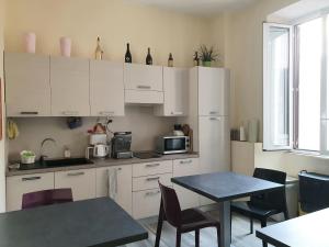 una cocina con armarios blancos y una mesa con sillas. en Holidays in Rome - Guesthouse, en Roma
