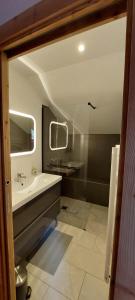 a bathroom with a tub and a sink and a mirror at Magnifique duplex au pied des pistes, rénové dans maison de pays in Le Monêtier-les-Bains