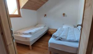 two beds in a small room with a window at Magnifique duplex au pied des pistes, rénové dans maison de pays in Le Monêtier-les-Bains
