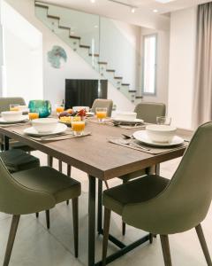 a dining room with a wooden table and chairs at Napa Hills Seaview Villas in Ayia Napa