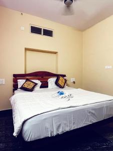 ein Schlafzimmer mit einem großen Bett mit weißer Bettwäsche und Kissen in der Unterkunft Goud's Home stay in New Hampi