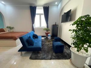 a living room with a bed and a blue couch at Queen Sea Hotel in Phan Thiet