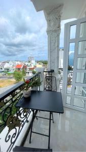 - une table noire sur un balcon avec vue sur l'océan dans l'établissement Queen Sea Hotel, à Phan Thiết