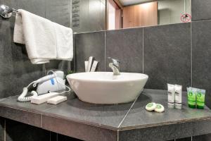a bathroom with a white sink on a counter at White Olive Premium Laganas in Laganas