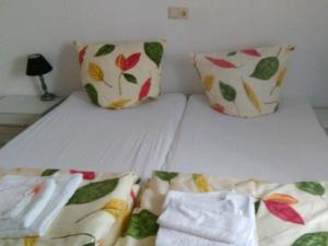 ein Bett mit zwei Kissen und einem weißen Bettlaken in der Unterkunft Fewo Reutlingen Metzstraße in Reutlingen