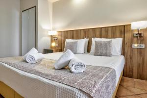 a bedroom with a large bed with towels on it at White Olive Premium Laganas in Laganas
