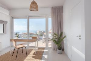 a dining room with a table and a large window at Athenian Riviera Panorama Villa in Athens