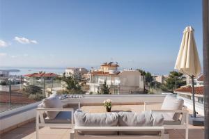 Athenian Riviera Panorama Villa في أثينا: شرفة مع أريكة وإطلالة على المحيط