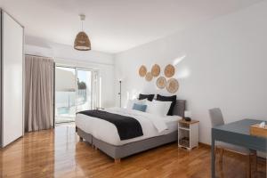 a white bedroom with a bed and a desk at Athenian Riviera Panorama Villa in Athens