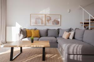 a living room with a gray couch and a coffee table at Athenian Riviera Panorama Villa in Athens +58 photos