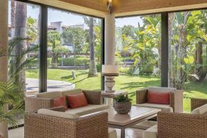 a conservatory with chairs and a table and a large window at Precise Resort El Rompido-The Club in El Rompido