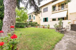 una casa con un árbol y rosas rojas en el patio en Vintage Apartment with Garden View / Free Parking, en Florencia