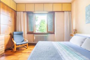 1 dormitorio con 1 cama, 1 silla y 1 ventana en Vintage Apartment with Garden View / Free Parking, en Florencia