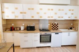 a kitchen with white cabinets and a stove at Grande maison en pierre à Pomerol - 3 chambres, parking, proche Saint-Emilion in Pomerol