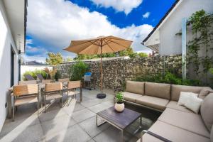 a patio with a couch and an umbrella at Lubminer Meerblick Apartments in Lubmin