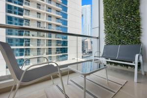 two chairs and a glass table on a balcony at Exclusive Dubai Marina Two Bedroom Suite by Jumeirah Beach, Mall and Metro in Dubai