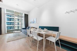 a dining room with a table and white chairs at Exclusive Dubai Marina Two Bedroom Suite by Jumeirah Beach, Mall and Metro in Dubai