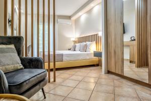 a bedroom with a bed and a chair at White Olive Premium Laganas in Laganas