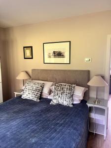 ein Schlafzimmer mit einem blauen Bett mit Kissen darauf in der Unterkunft The Coach House in Warnham